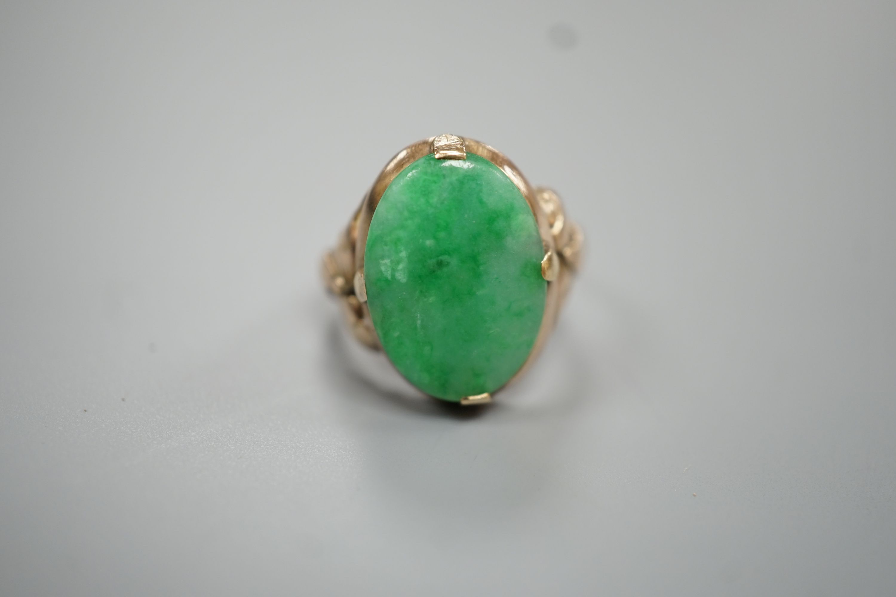 A yellow metal and oval cabochon jade set ring, size K/L, gross weight 3.5 grams.